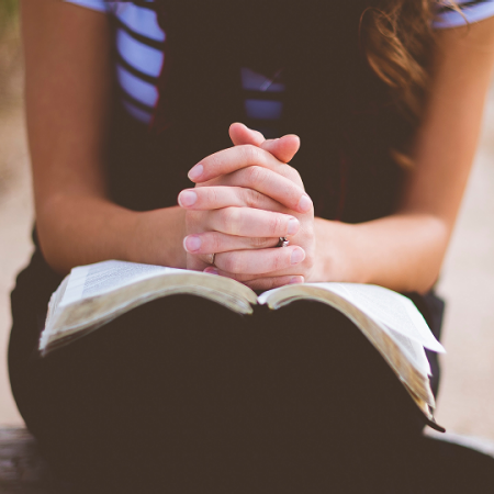 clasped hands of people in prayer